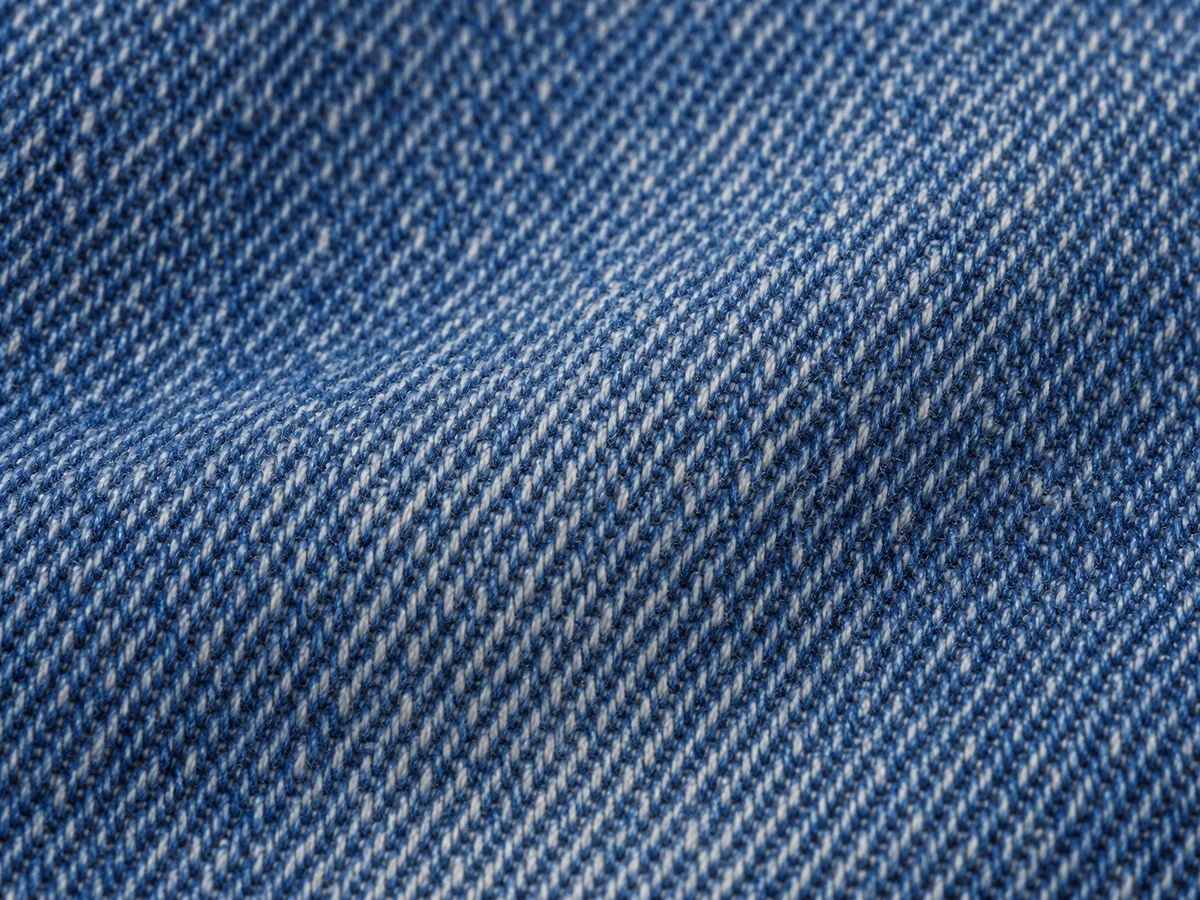 Macro view showing diagonal denim weave in indigo and pale yarns